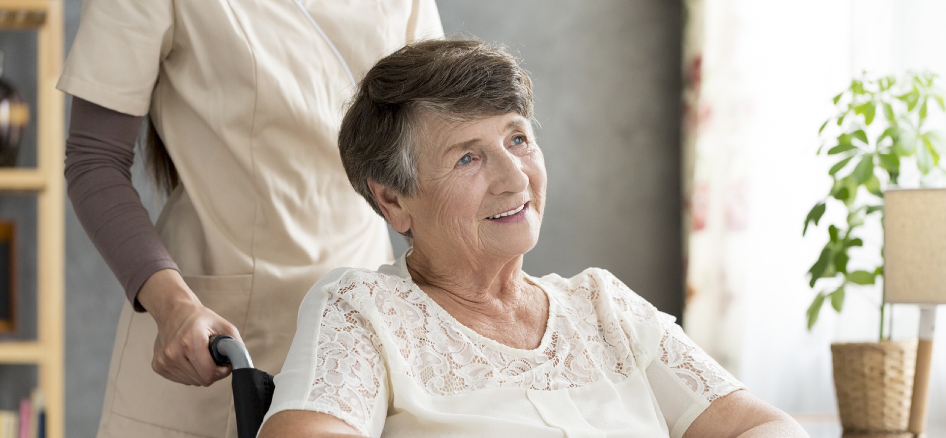Betreuungskraft begleitet eine Seniorin in ihrer vertrauten Wohnung